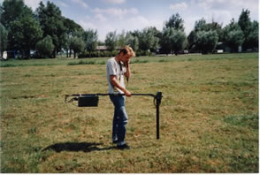 met de metaal detector in het weiland